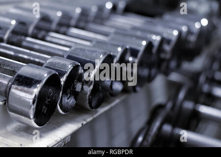 Close up of small weight metallic dumbbells in a row. Stock Photo