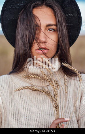 Portrait of young woman with ears wearing hat and turtleneck pullover Stock Photo