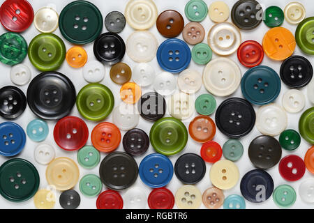 Old colorful sewing buttons on white table Stock Photo