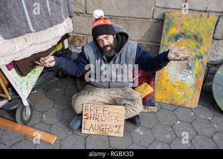 A busker, street performance artist & painter giving free shrugs but selling laughs for $1 each. In Union Square Park in Manhattan, New York City. Stock Photo
