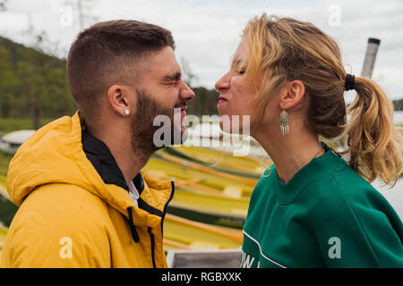 Finland, Lapland, funny young couple grimacing at the lakeside Stock Photo