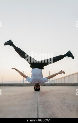 Man doing breakdance in urban concrete building, standing on head Stock Photo