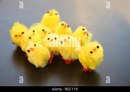 Group of artificial funny small yellow chicks, which is a symbol of Easter & often used as decorations. Some of the chicks are quirky & fallen over. Stock Photo