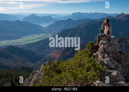 Germany, Upper Bavaria, Aschau, hiker sitting on viewpoint at Kampenwand Stock Photo