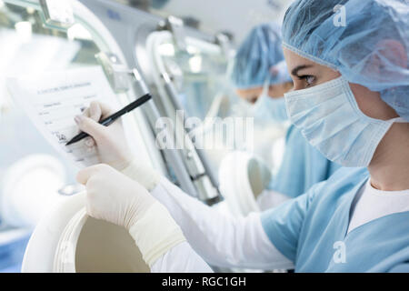 Scientist taking notes in laboratory Stock Photo