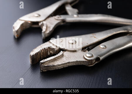 An old special clamping key for a plumber. Tools for home repairs. Dark background. Stock Photo