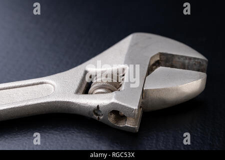 An old special wrench for a plumber. Tools for home repairs. Dark background. Stock Photo