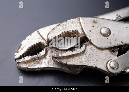 An old special clamping key for a plumber. Tools for home repairs. Dark background. Stock Photo