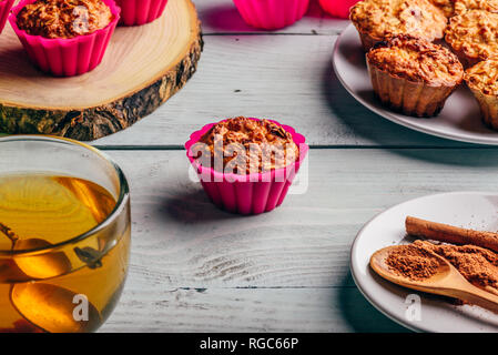 Healthy Dessert. Oatmeal muffins with cup of green tea over light wooden background. Stock Photo