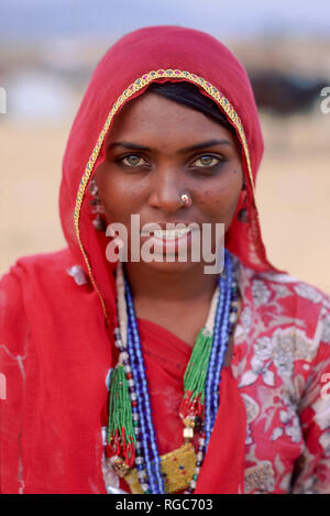 Young Indian woman portrait wearing traditional sari, jewelry and a red veil, Thar Desert, Northern India Stock Photo