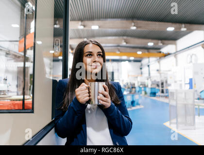 Confident woman working in high tech enterprise, drinking coffee Stock Photo