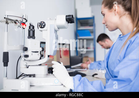 Lab technician working with microscope in lab Stock Photo