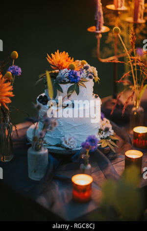 Wedding cake on table with candles outdoors Stock Photo