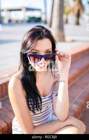 Portrait of laughing young woman with nose piercing and tattoos