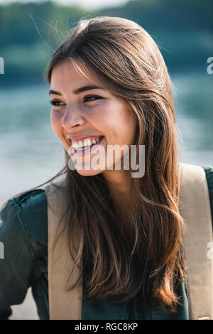 Portrait of happy young woman sitting outdoors Stock Photo