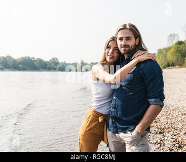 Happy young couple in love embracing at the riverside Stock Photo