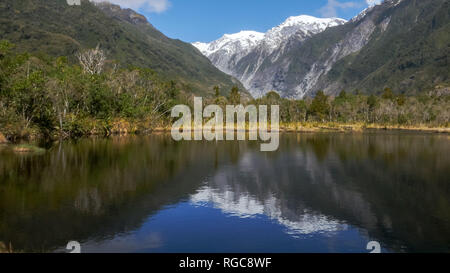 calm waters of peter's pool at franz josef glacier in new zealand Stock Photo