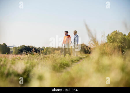 Two old friends taking a stroll through the fields, talking about old times Stock Photo