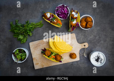 Sweet potato falafel in taco shells, with red cabbage, salad, carrot, yogurt sauce and black sesame Stock Photo