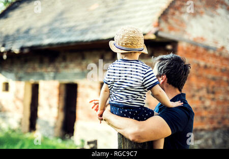 Back view of father and little son watching something outdoors Stock Photo