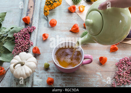Woman's hand pouring tea in a cup Stock Photo