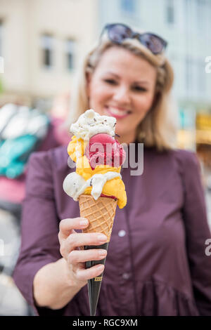 Woman holding ice cream cone with various sorts of ice cream Stock Photo