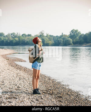 Happy young woman standing at the riverside Stock Photo
