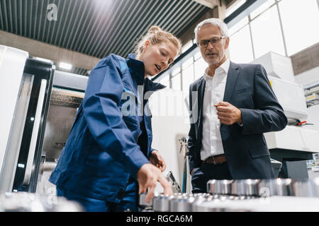 Manager and skilled worker in high tech enterprise, checking machine parts Stock Photo