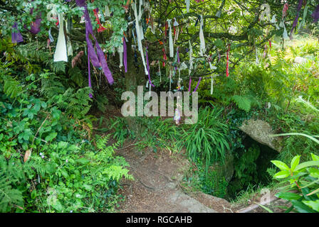 The Sancreed Holy Well in Cornwall beside a 'cloutie tree', bedecked with strips of cloth, as part of a pagan or celtic tradition. Stock Photo