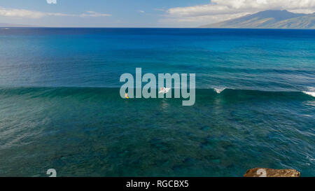a surfer rides a longboard at honolua bay, maui in hawaii Stock Photo