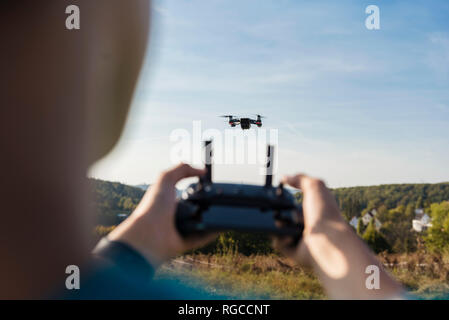 Boy navigating a flying drone outdoors Stock Photo
