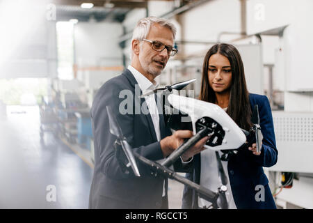 Businessman an woman in high tech enterprise, discussing production of drones Stock Photo