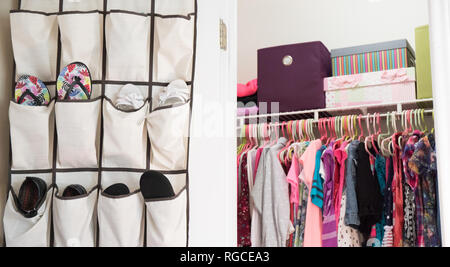 A young girl's closet neatly organized with bins and boxes. Stock Photo