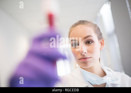 Scientist in lab examining blood sample Stock Photo