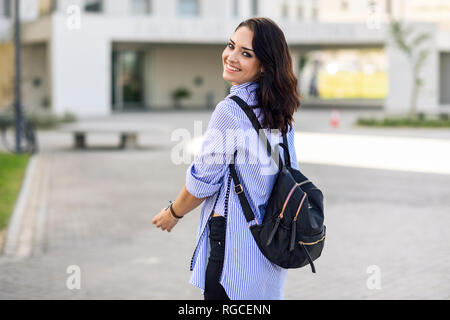 Portrait of smiling student with backpack on campus Stock Photo