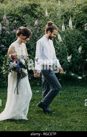 bride and groom walking hand in hand Stock Photo - Alamy