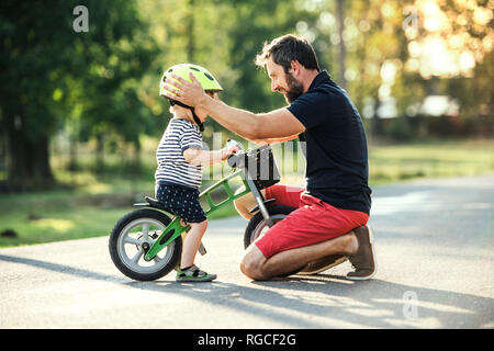 Father supporting little son on bike Stock Photo
