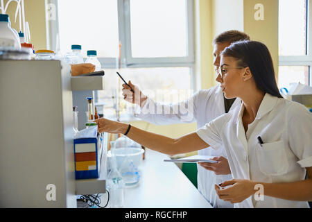 Young man and woman working together in laboratory Stock Photo