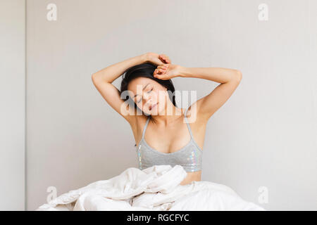 Young woman in bed waking up Stock Photo