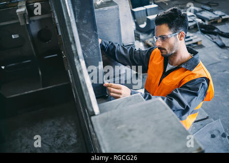 Man wearing protective workwear working in factory Stock Photo
