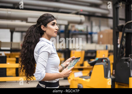 Woman holding tablet in factory shop floor Stock Photo
