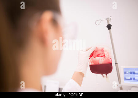 Scientist working with blood bag in lab Stock Photo