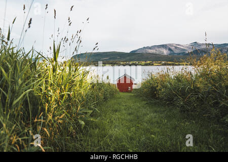 Northern Norway, Lapland, Red wood house at a fjord Stock Photo