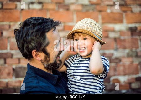 Portrait of happy toddler on his father's arms Stock Photo
