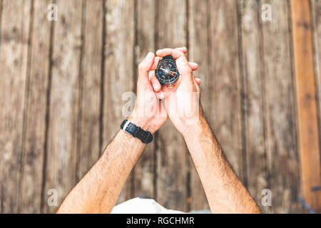 Close-up of man on boardwalk holding a compass Stock Photo