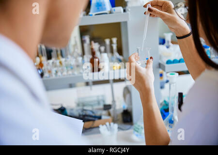 Young woman pipetting in laboratory Stock Photo