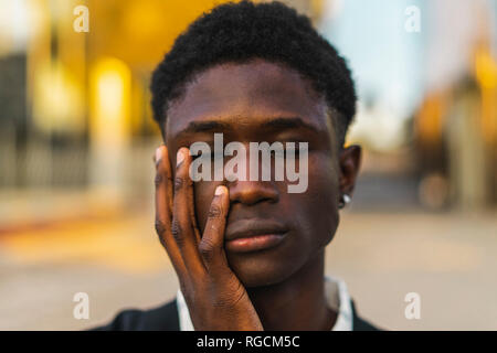 Young black man with closed eyes and hand on face Stock Photo