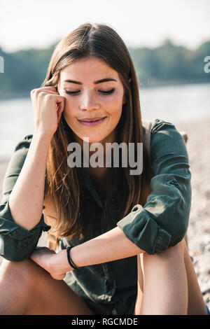 Portrait of smiling young woman sitting outdoors Stock Photo