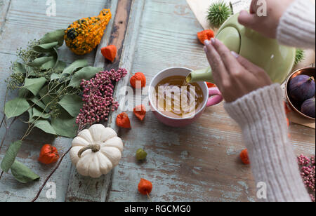 Woman's hands pouring tea in a cup Stock Photo