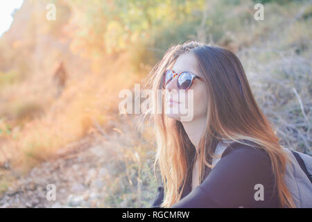 Young woman on a hiking trip wearing sunglasses Stock Photo